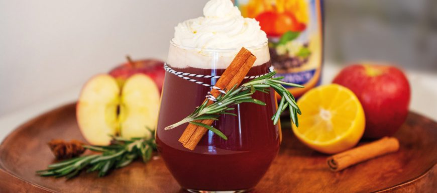 Winterpunsch mit Dekoration aus Äpfeln Zitrone Zimt Rosmarin